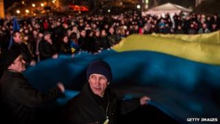 People wave a large Ukrainian flag in Independence Square on February 23, 2014 in Kiev, Ukraine