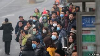 This picture taken on 24 February 2014 shows residents waiting for buses in a bus station in haze-covered Beijing