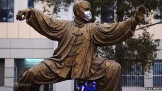 A statue with a face mask at Peking University