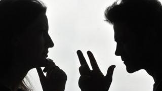 A silhouetted couple arguing