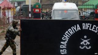 An army soldier opens the gates of the Rashtriya Rifles camp for a team of medics leaving after conducting post-mortems on the bodies of five soldiers killed at an army camp at Safapora some 20 kms (12 miles) from Srinagar on February 27, 2014