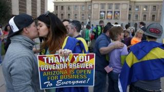 Gay rights supporters kiss after in Phoenix, Arizona, after Governor Jan Brewer vetoed an 'anti-gay' bill on 26 February 2014