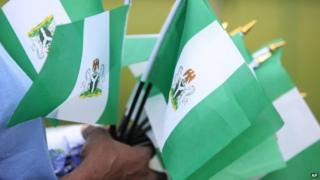 An unidentified woman sells Nigerian national flags, during an event to mark Nigeria independence day, in Lagos, Nigeria. Tuesday 1 October 2013