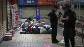 Policemen check unclaimed luggage at a square outside the Kunming railway station after a knife attack, in Kunming, Yunnan province, on 2 March 2014