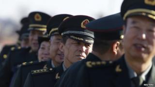 Military delegates from the Chinese People's Liberation Army gather outside the Great Hall of the People for a plenary meeting of the National People's Congress in Beijing, 4 March 2014