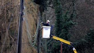Engineer works on repairing electricity power lines near Reigate in Surrey after floods hit the area