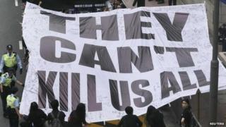 Demonstrators carry a banner that reads "They can't kill us all" during a march against violence on journalists in Hong Kong, 2 March 2014