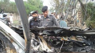 Two members of the bomb disposal unit inspect bomb wreckage