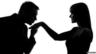 Man kissing hand of woman