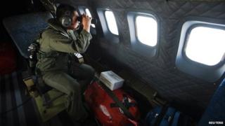 A member of the Malaysian air force looks out over the Straits of Malacca during the search operation