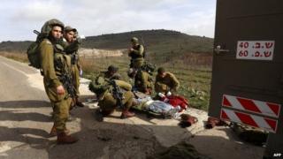 A wounded Israeli soldier is prepared for evacuation by medics near the town of Majdal Shams (18 March 2014)