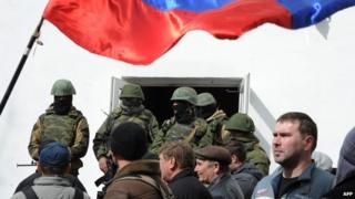 Russian soldiers and pro-Russian self-defence activists patrol at the Ukrainian navy headquarters in the Crimean city of Sevastopol