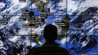 A man watches a large screen showing different flights at the departure hall of Kuala Lumpur International Airport 13 March 2014
