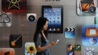 A customer passes an Apple store where the latest version of the Apple iPad