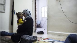 Syrian woman and child in room in Zarqa (file photo)