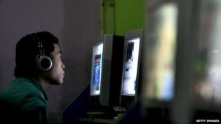A man looks at a computer screen in a Chinese internet cafe