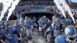 University of North Carolina football players run onto the field in 2010.