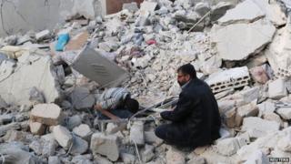 Civilians search under the rubble at a site hit by what activists said were barrel bombs dropped by forces loyal to President Bashar al-Assad in the Karam Homad district of Aleppo (26 March 2014)