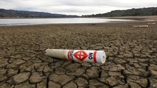 A warning buoy sits on the dry, cracked bed of Lake Mendocino, California
