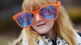 US woman wears large sunglasses with a 'Stop spying' message during an anti-government surveillance rally in Washington (28 March 2014)
