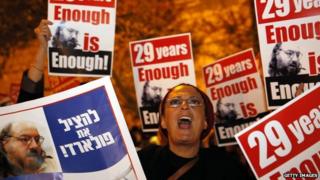 An Israeli protesting the imprisonment of Jonathan Pollard holds up a sign reading "enough is enough".