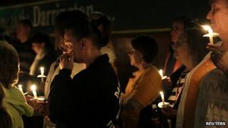 People participate in a candlelight vigil at the Community Center in Darrington, Washington, on 5 April 2014