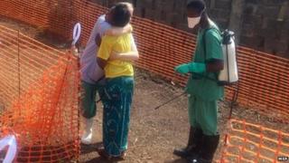 Rose Komano, who has recovered from Ebola, is hugged by a nurse in Guinea