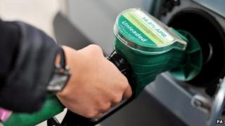 A close-up of someone's hand on a petrol pump