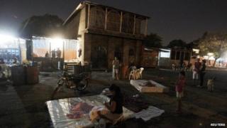 People gather in the streets outside their homes after an earthquake shook Managua on 13 April 2014