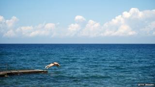 A swimmer jumps into the sea in the Adriatic town of Izola in September 2013.