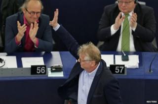 Daniel Cohn-Bendit waves as he is applauded by fellow MEPs after his last speech to the European Parliament in Strasbourg, 16 April