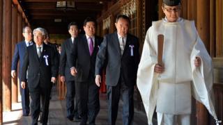 Japanese lawmakers follow a Shinto priest during a visit to the controversial Yasukuni shrine to honour the war dead at shrine's spring festival in Tokyo on 22 April, 2014