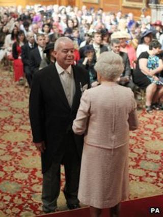 The Queen presents Richard Hook with his ambulance service medal