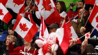 Canadians wave their nation's flag.