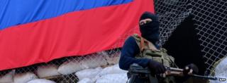 An armed man in military fatigues stands guard outside a regional administration building seized by the separatists in the eastern Ukrainian city of Sloviansk on April 23