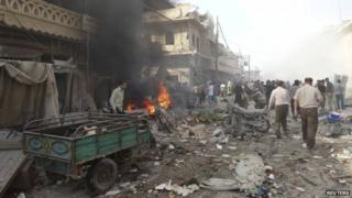 People inspect a site hit by what activists said were barrel bombs dropped by forces loyal to Syria's President Bashar al-Assad in the northern town of Atareb, in Aleppo province, 24 April 2014
