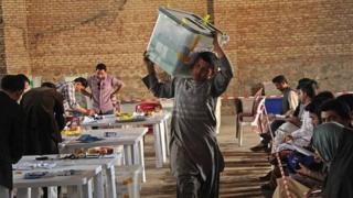 A worker for the Afghan election commission office unloads ballot boxes in Herat Province (20 April 2014)