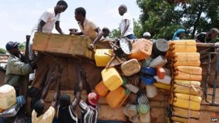 People stand atop a vehicle loaded with people and goods in the PK-12 district of Bangui