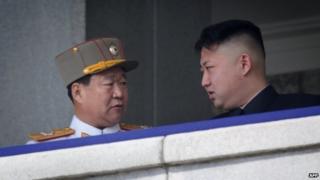 Man believed to be Choe Ryong-Hae (L) talking to North Korean leader Kim Jong-Un (R) at a military parade in Pyongyang (15 April 2013)