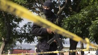 A police officer at the scene of a gang shooting in El Salvador - 13 April 2014