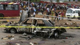 A damaged car at the scene of a bomb attack in Abuja - 2 May 2014
