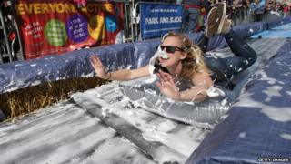 A girl wizzes down a giant slide