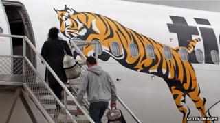 Passengers embark a Tiger Airways flight