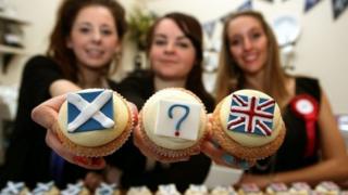girls holding cakes with flags