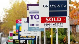For sale signs line a street