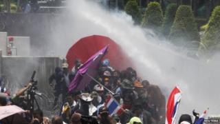Police fire teargas and water cannon at anti-government protesters at a police compound housing a government security group in the north of Bangkok on 9 May.