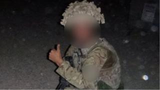 A photograph showing a man in uniform giving a "thumbs up"