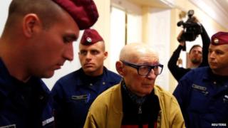 Hungary's former interior minister Bela Biszku escorted by police to his trial in Budapest (13 May)