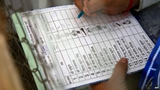 An Indian polling agent notes down the numbers of votes after an Electronic Voting Machine (EVM) was opened by election officials at a counting centre in Ghaziabad on May 16, 2014.