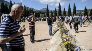 People mourn their relatives at the cemetery where some of the 301 people killed in the Soma disaster were buried, on May 18, 2014